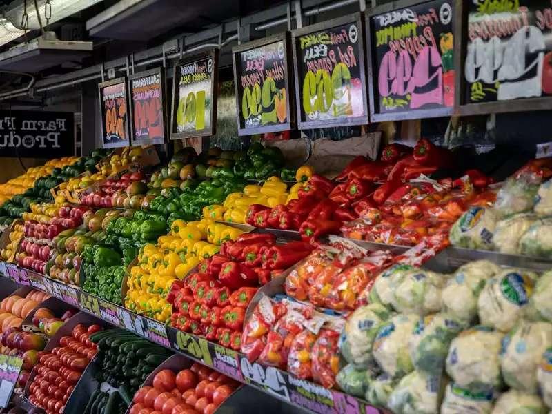 colorful vegetables in bins with price signs above